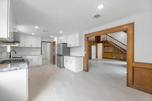 a kitchen with a refrigerator and a stove top oven