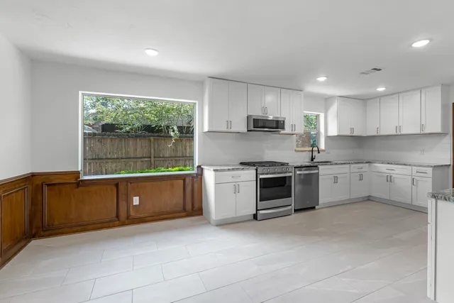 a kitchen with a stove sink and cabinets