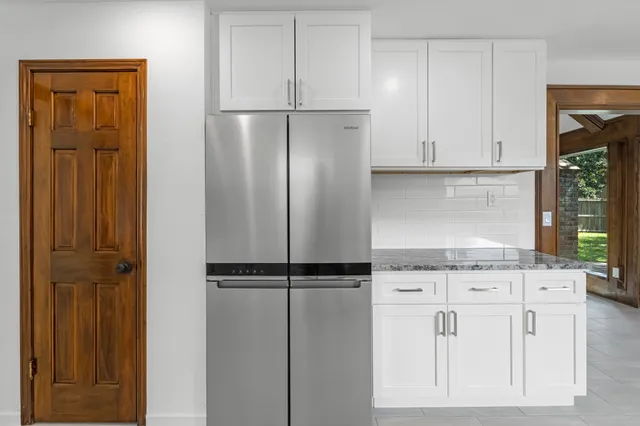 a kitchen with a refrigerator and cabinets