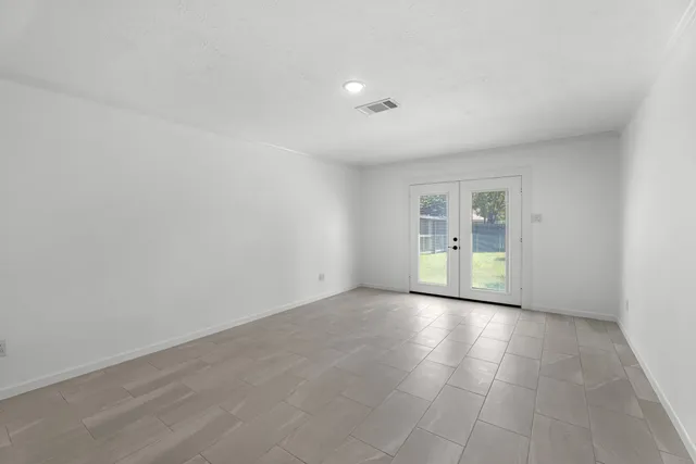 a view of empty room with wooden floor and windows