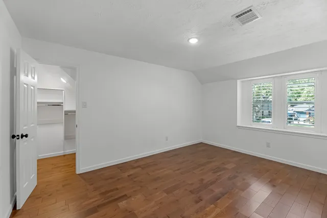 an empty room with windows and closet