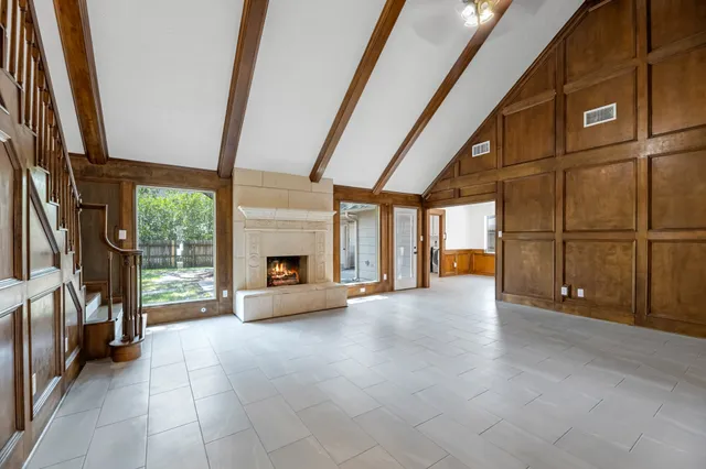 a view of an empty room with a fireplace and a window