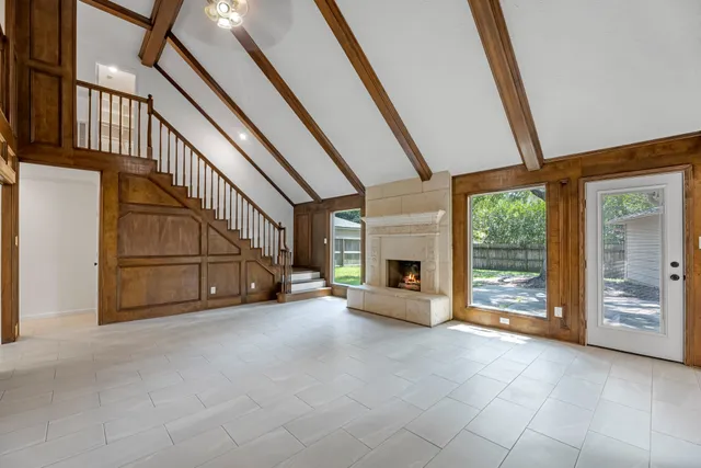 a view of an empty room with wooden floor and windows