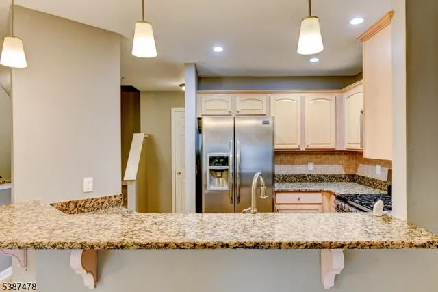 a kitchen with stainless steel appliances granite countertop a sink refrigerator and microwave