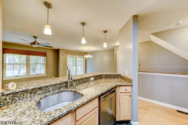 a kitchen with granite countertop a sink and a chandelier