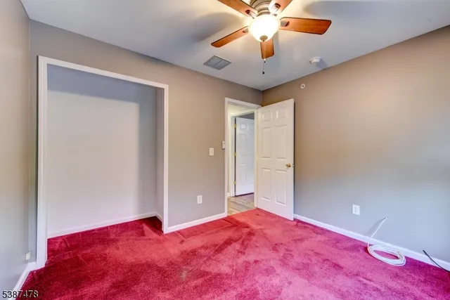 a view of a bedroom with a bed and a chandelier fan