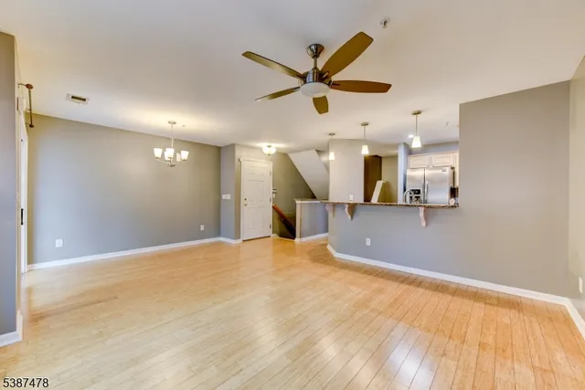 a view of a livingroom with a ceiling fan and kitchen view