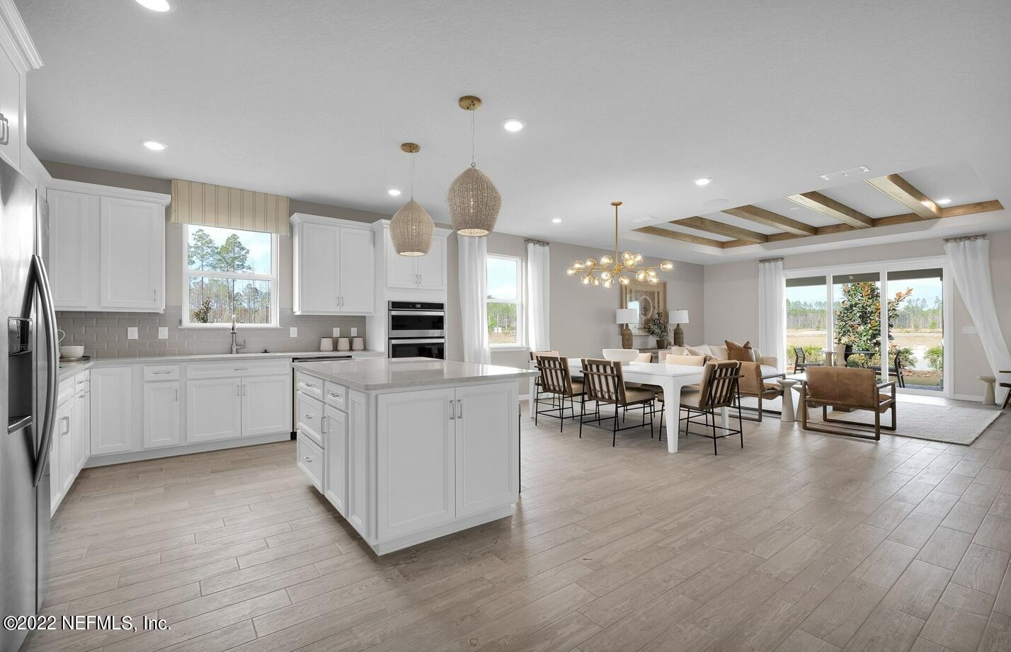 a large white kitchen with lots of counter top space and living room