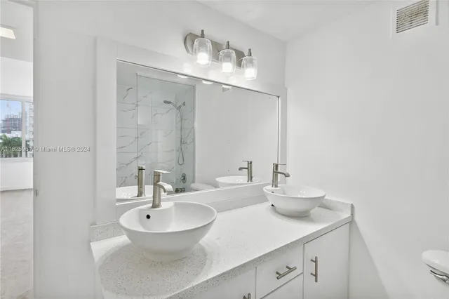a bath tub sitting next to a white sink and vanity