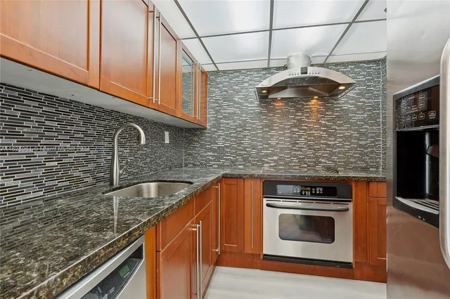 a kitchen with stainless steel appliances granite countertop cabinets and a counter top space