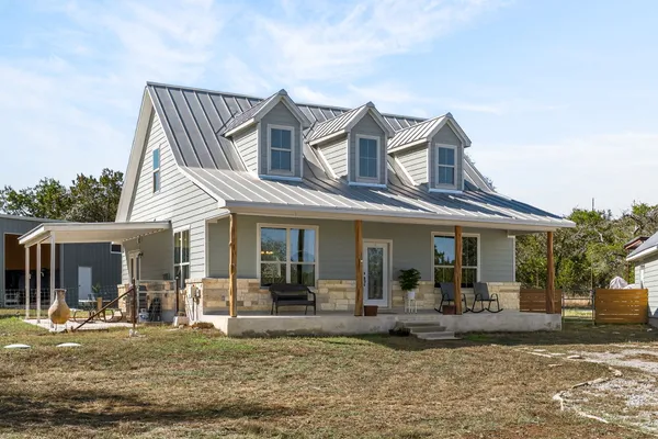a view of a house with a patio and a yard