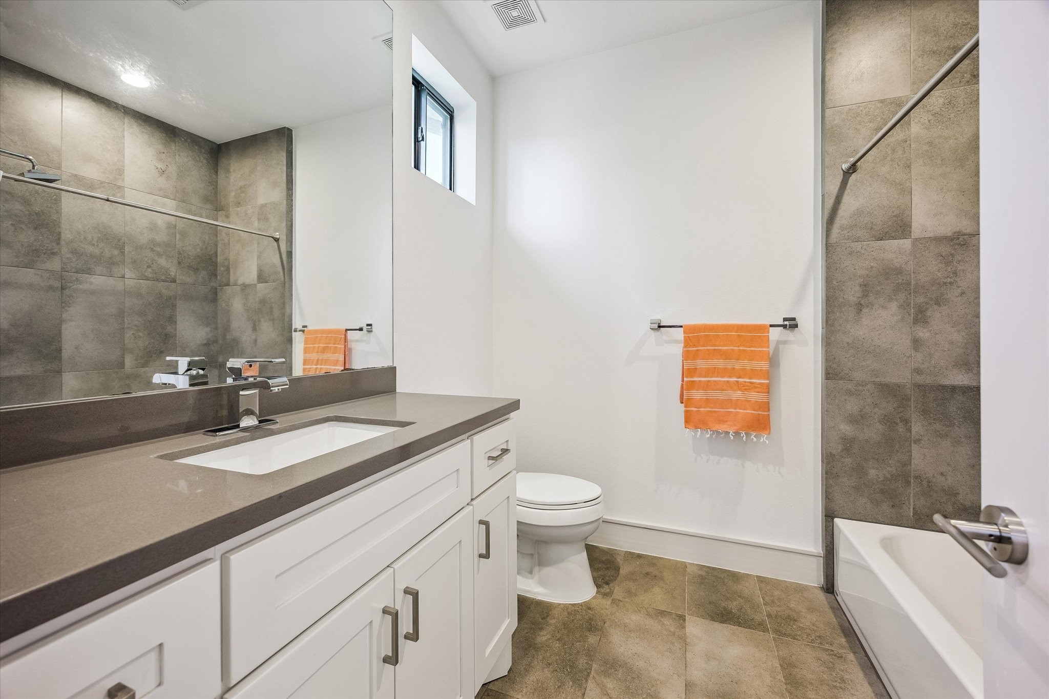 1810 Ridgewood Street Houston, TX 77006 - Photo 22 of 30 FULL BATHROOM features tub/shower combo with porcelain tile surround, engineered quartz counter, mirrored vanity & cabinetry. Porcelain 12x14" flooring.