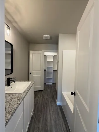 a bathroom with a granite countertop sink a toilet and shower