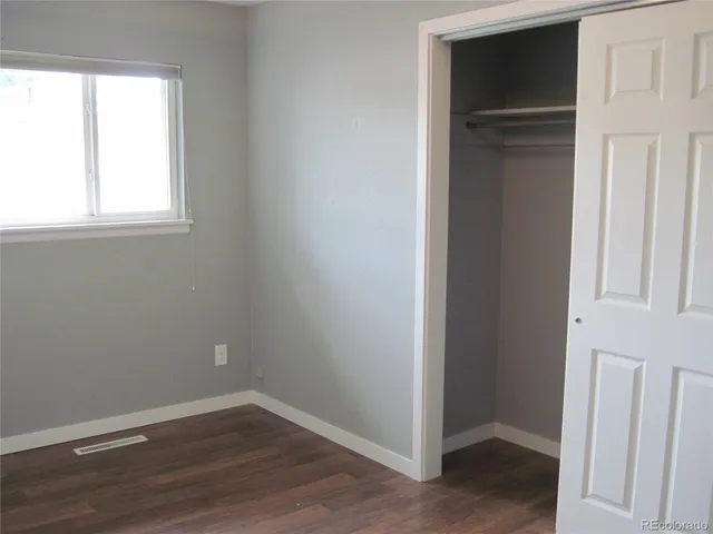 an empty room with wooden floor and closet