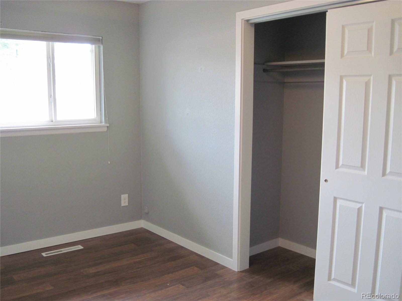 1014 Alexander Road Colorado Springs, CO 80909 - Photo 16 of 44 an empty room with wooden floor and closet