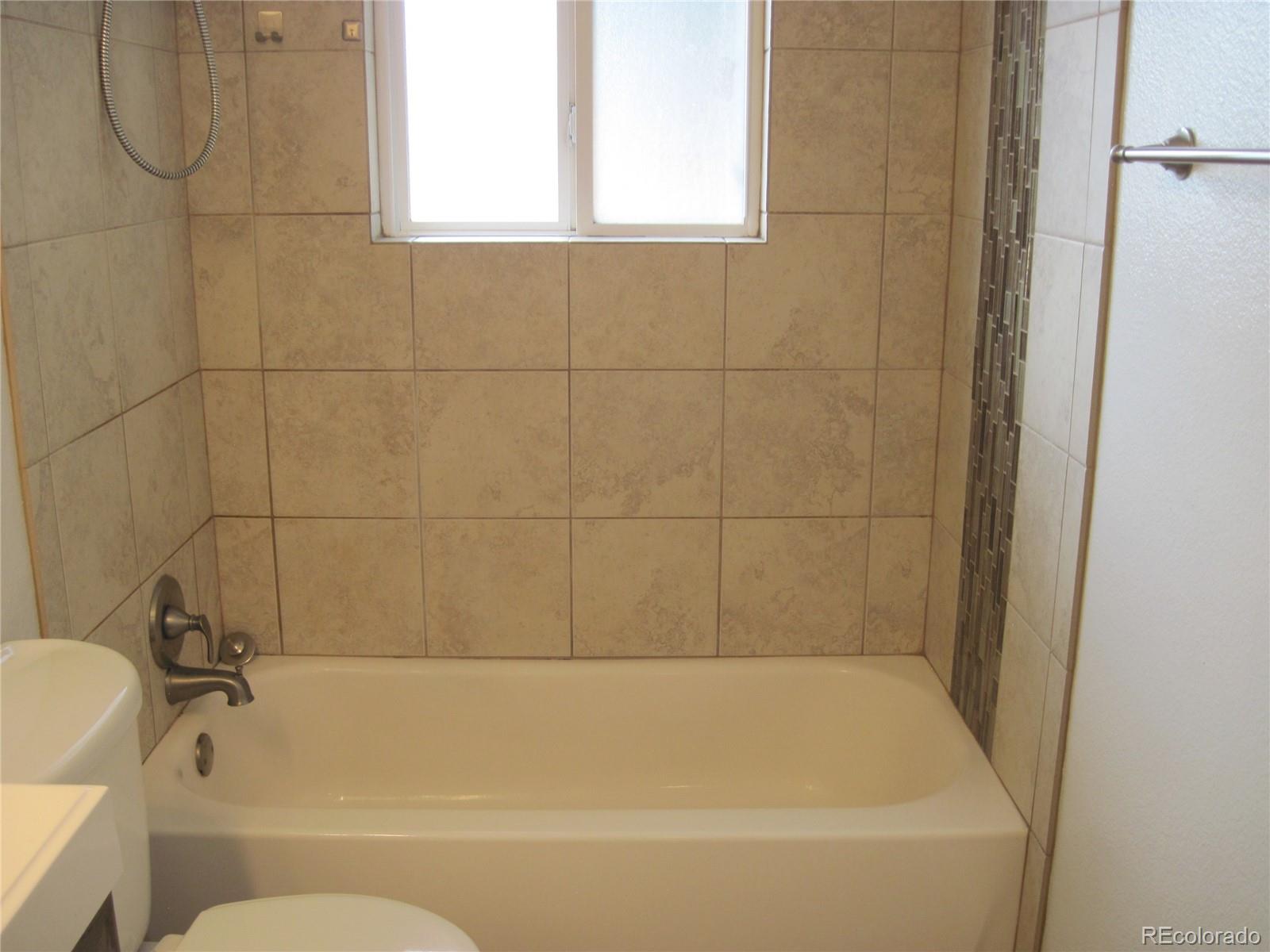 1014 Alexander Road Colorado Springs, CO 80909 - Photo 19 of 44 a bathroom with a bathtub and a shower