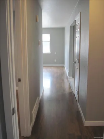 a view of a hallway with wooden floor