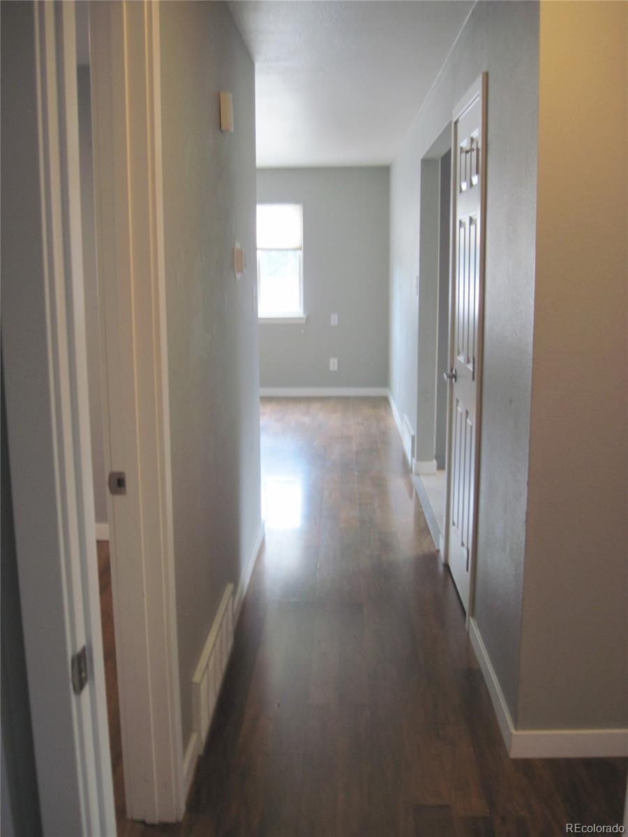 1014 Alexander Road Colorado Springs, CO 80909 - Photo 22 of 44 a view of a hallway with wooden floor