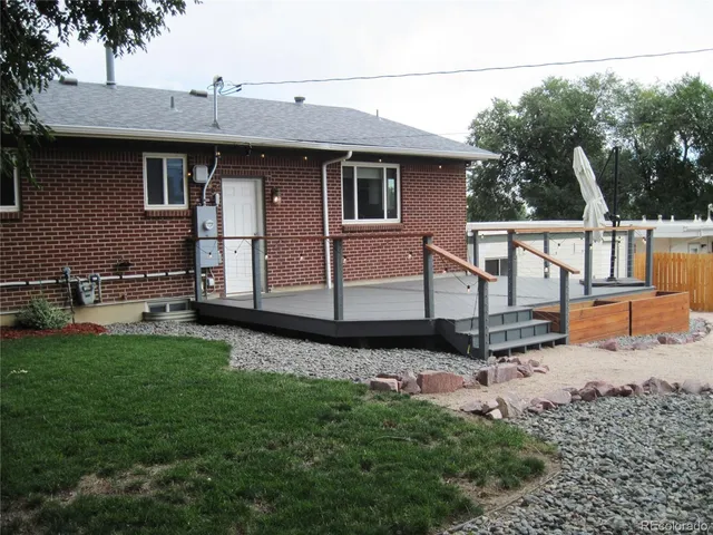 a view of a backyard with plants and a bench