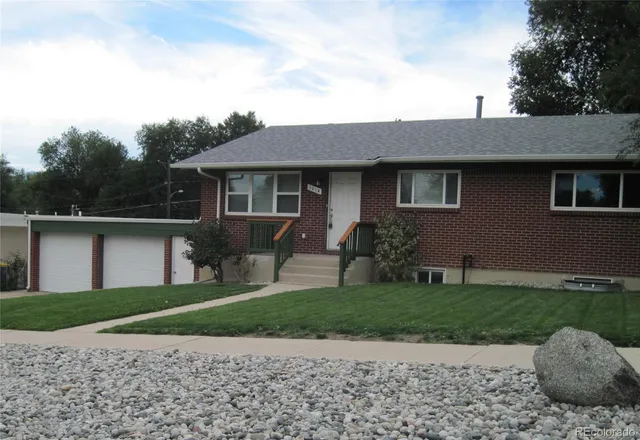 a front view of a house with a yard and potted plants