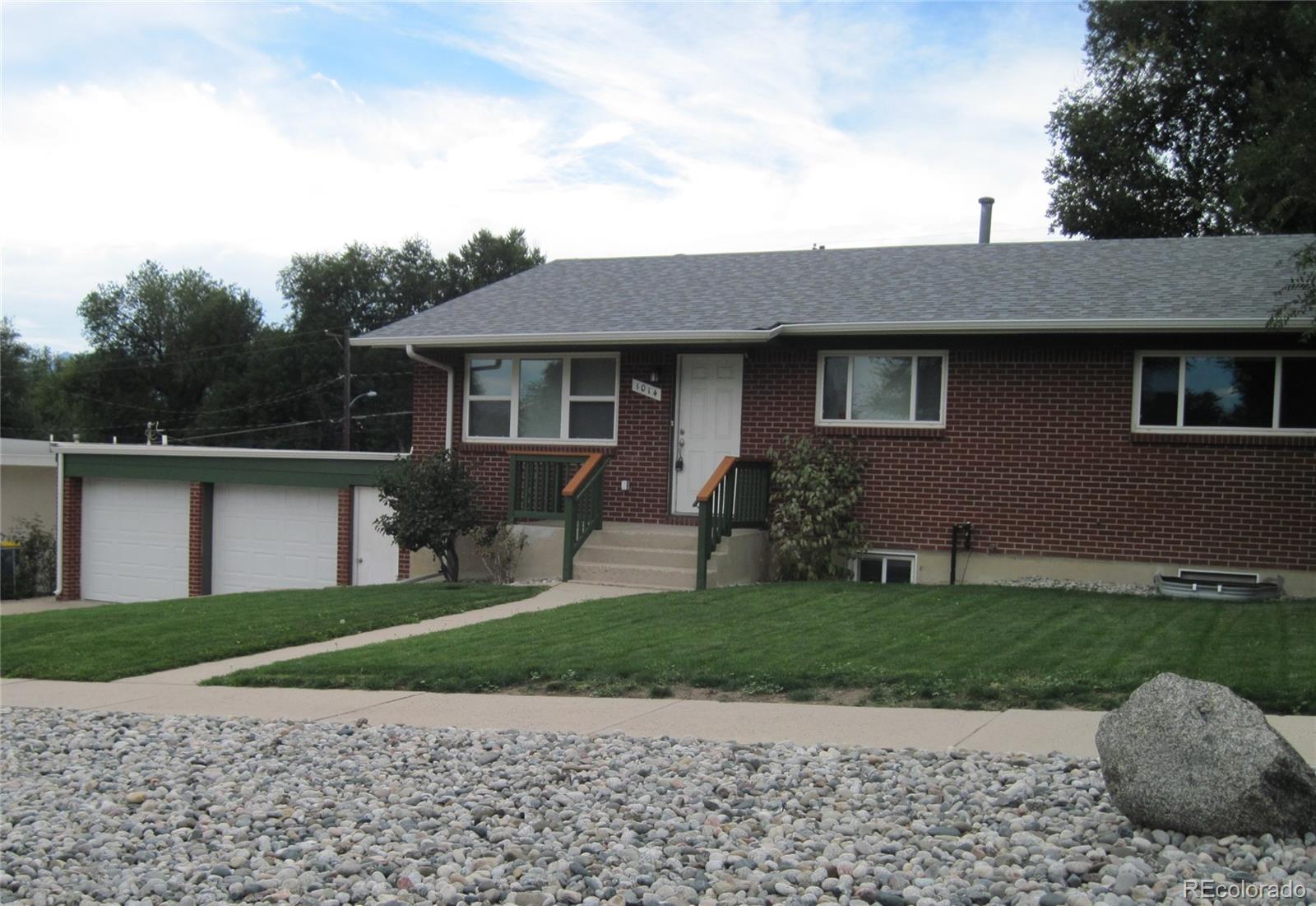 1014 Alexander Road Colorado Springs, CO 80909 - Photo 4 of 44 a front view of a house with a yard and potted plants