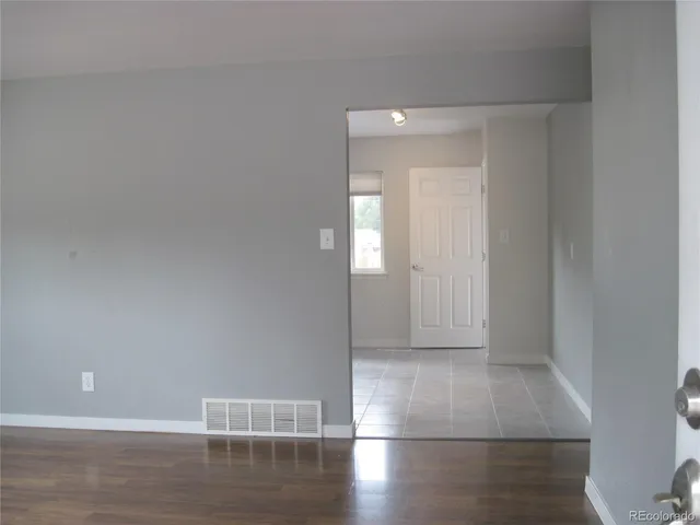 a view of empty room with wooden floor