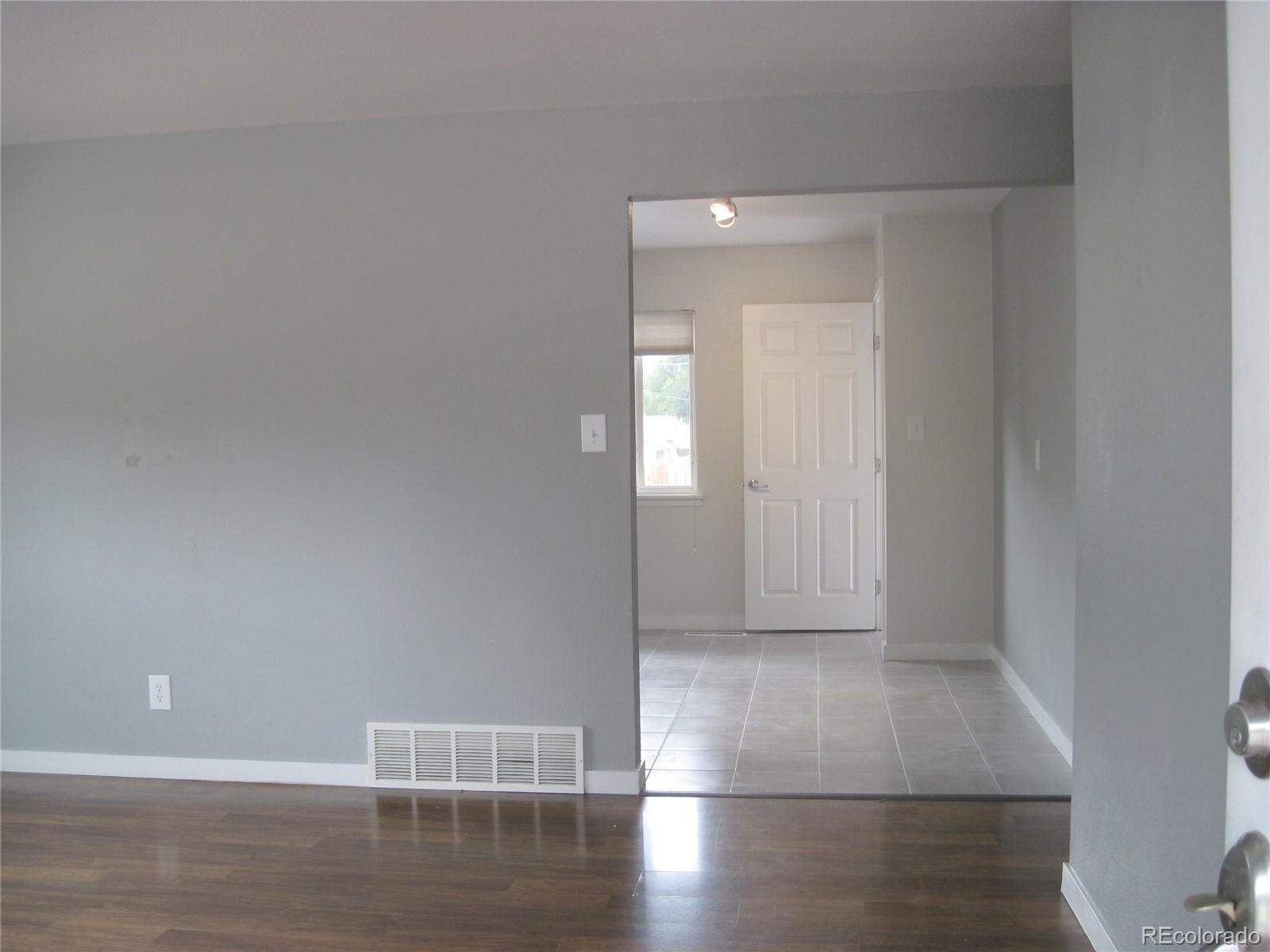 1014 Alexander Road Colorado Springs, CO 80909 - Photo 6 of 44 a view of empty room with wooden floor
