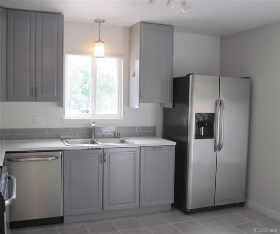 a kitchen with a sink window and refrigerator