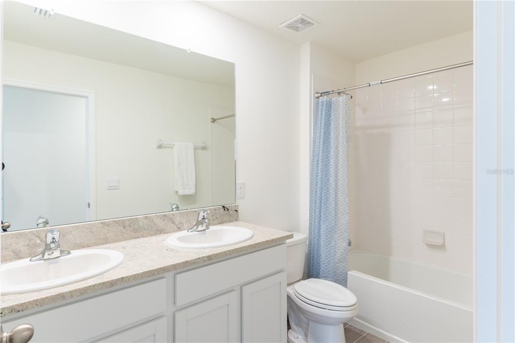 4807 Southwest 51st Terrace Gainesville, FL 32608 - Photo 30 of 35 a bathroom with a granite countertop sink toilet and shower