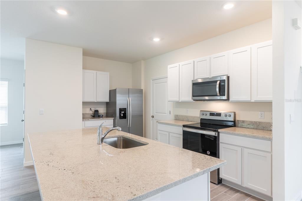 4807 Southwest 51st Terrace Gainesville, FL 32608 - Photo 8 of 35 a kitchen with a sink a stove top oven and refrigerator