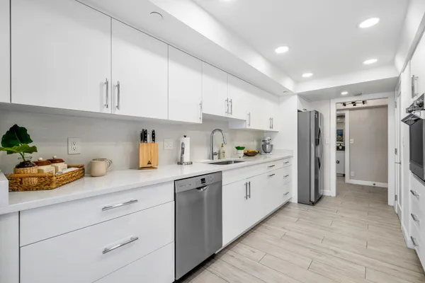 a kitchen with white cabinets and refrigerator