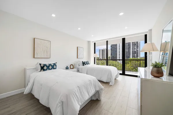 a bed room with two beds and a large window