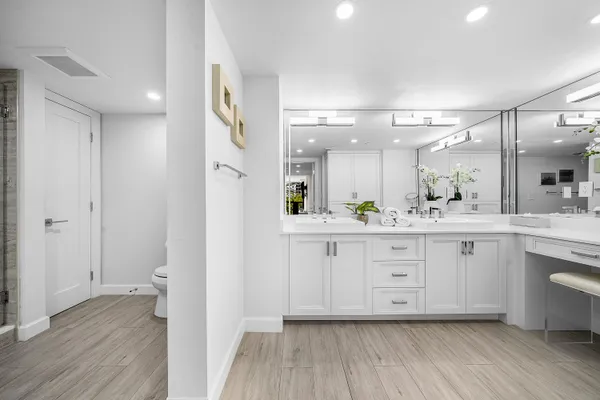a spacious bathroom with a granite countertop sink mirror and a toilet