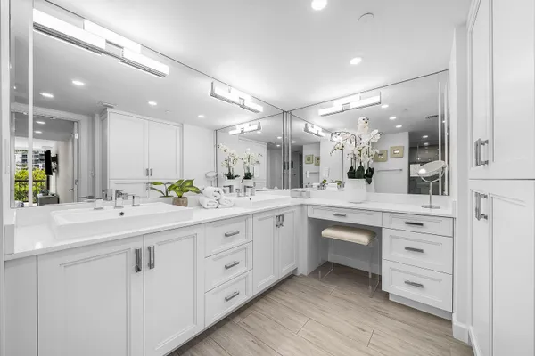 a large white bathroom with a double vanity sink and a mirror