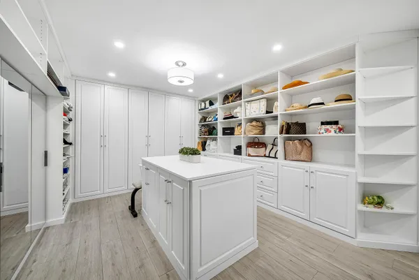 a kitchen with white cabinets and wooden floor
