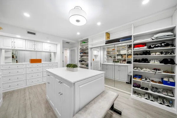 a kitchen that has a lot of cabinets in it and wooden floors
