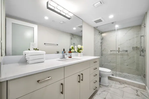 a bathroom with a double vanity sink toilet and shower