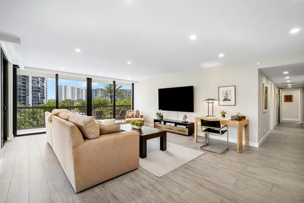 a living room with furniture flat screen tv and a large window