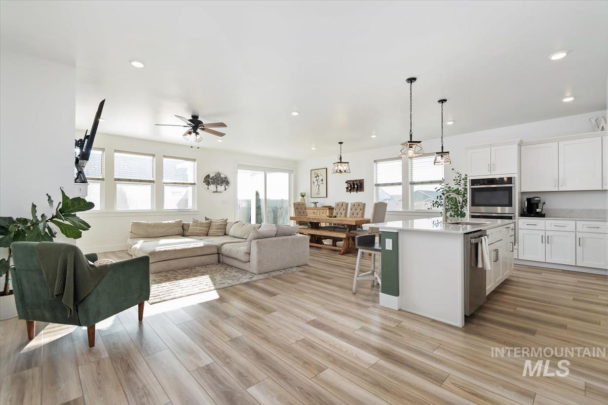 14361 Fractus Drive Caldwell, ID 83607 - Photo 48 of 50 Kitchen with open floor plan, white cabinetry, a center island with sink, a kitchen bar, and pendant lighting