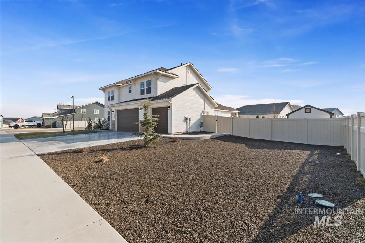 14361 Fractus Drive Caldwell, ID 83607 - Photo 34 of 50 View of front facade featuring a fenced backyard, a residential view, an attached garage, and driveway