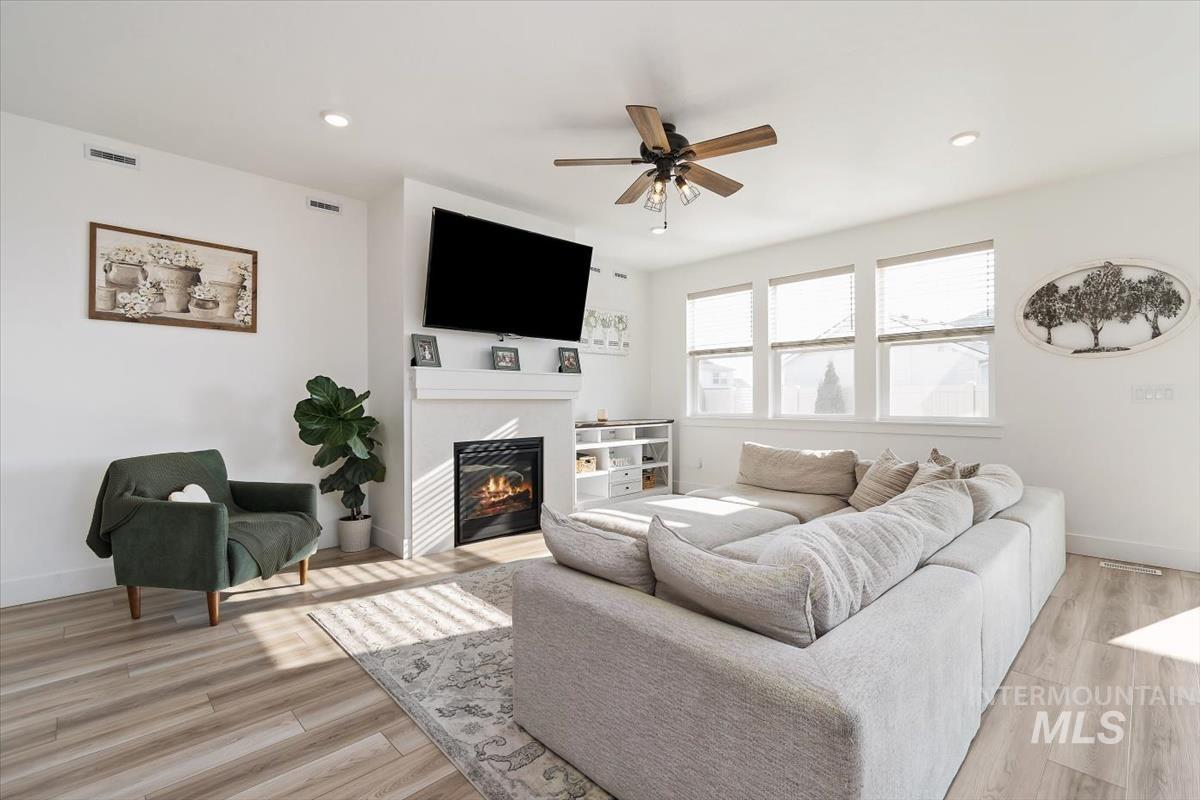 14361 Fractus Drive Caldwell, ID 83607 - Photo 3 of 50 Living room with a glass covered fireplace, light wood-type flooring, a ceiling fan, and recessed lighting