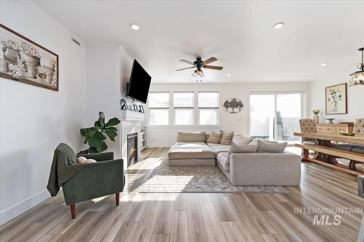 14361 Fractus Drive Caldwell, ID 83607 - Photo 5 of 50 Living room with a fireplace with flush hearth, light wood finished floors, a ceiling fan, and recessed lighting