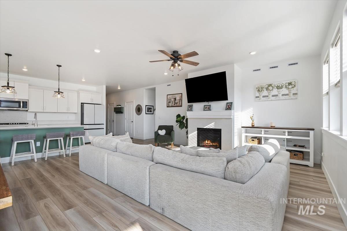 14361 Fractus Drive Caldwell, ID 83607 - Photo 6 of 50 Living room with a lit fireplace, recessed lighting, ceiling fan, and light wood finished floors