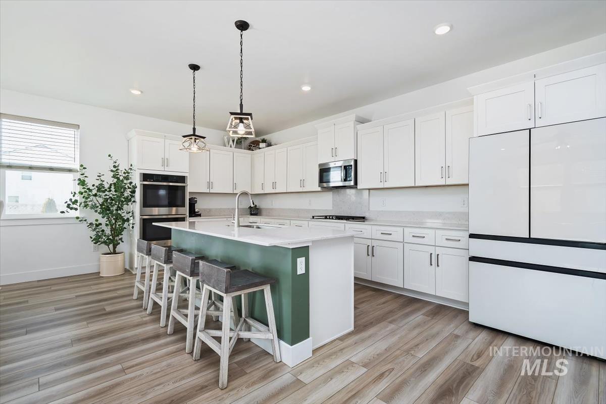 14361 Fractus Drive Caldwell, ID 83607 - Photo 7 of 50 Kitchen featuring white cabinets, hanging light fixtures, stainless steel appliances, a kitchen breakfast bar, and recessed lighting