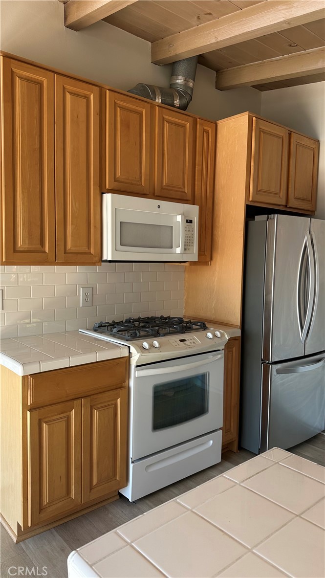 314 Avenida Granada, Unit C San Clemente, CA 92672 - Photo 8 of 13 a kitchen with stainless steel appliances granite countertop a refrigerator stove and cabinets