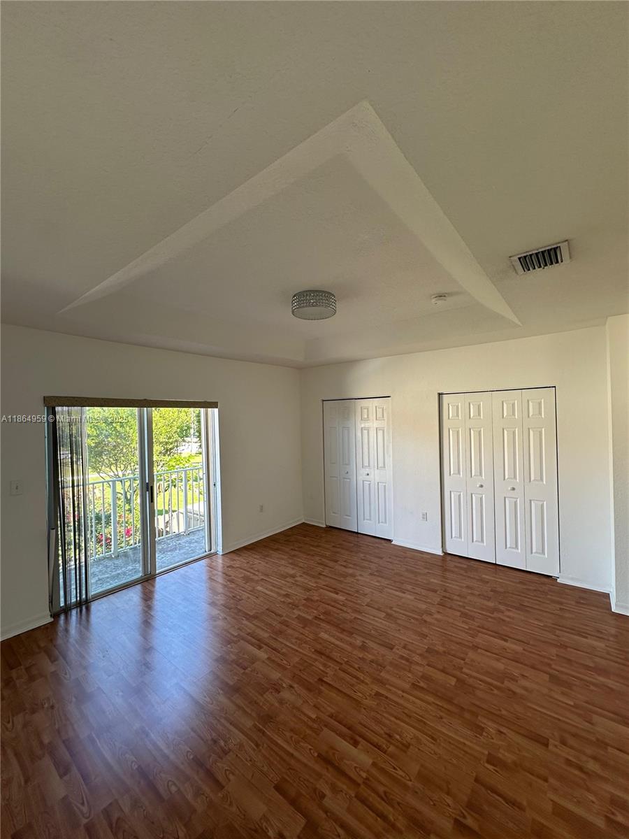 13713 Southwest 171st Lane Miami, FL 33177 - Photo 14 of 18 an empty room with wooden floor and windows
