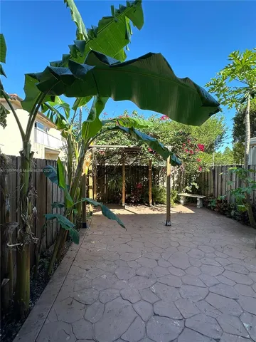 a view of a house with a yard and potted plants