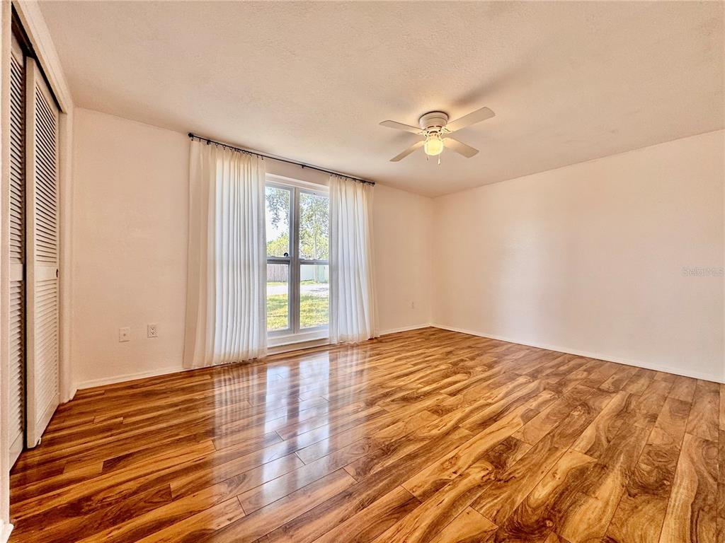 3902 Glissade Drive New Port Richey, FL 34652 - Photo 13 of 26 a view of empty room with wooden floor and fan