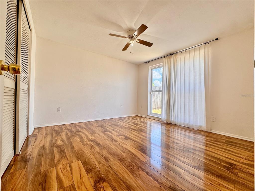 3902 Glissade Drive New Port Richey, FL 34652 - Photo 14 of 26 a view of empty room with wooden floor and fan