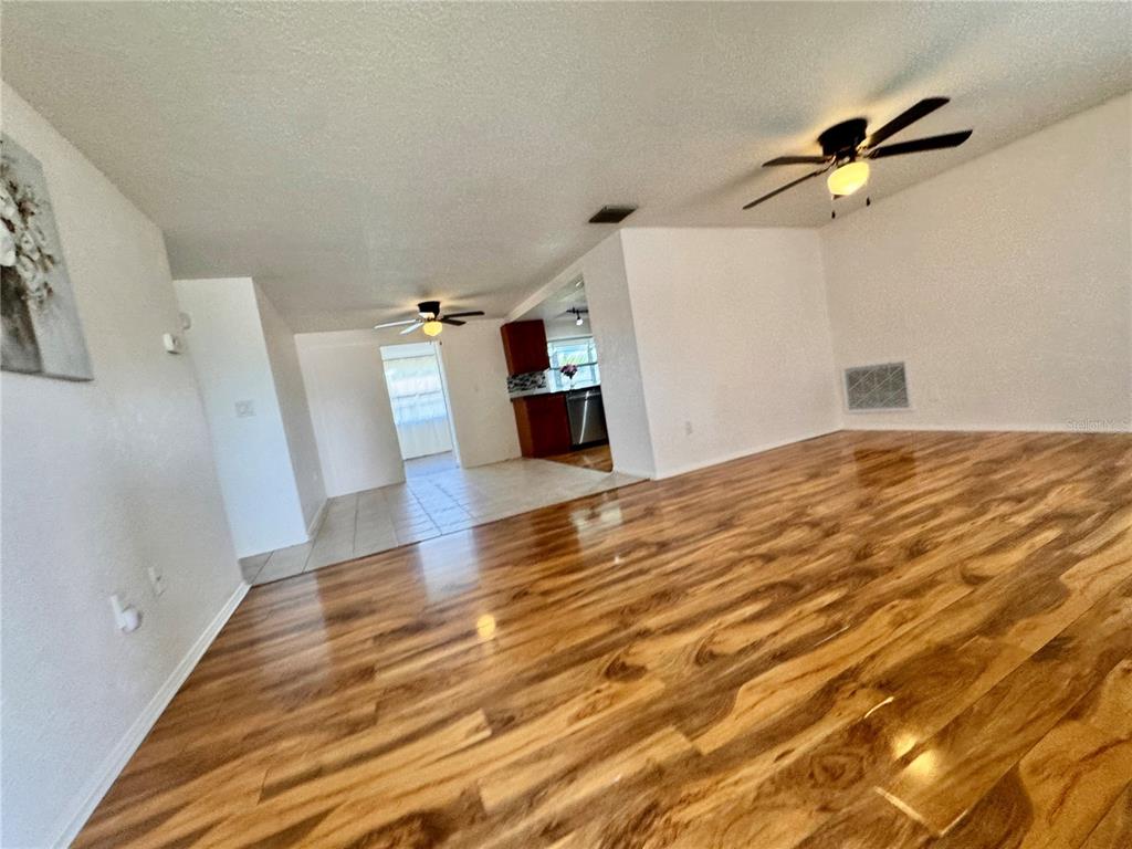 3902 Glissade Drive New Port Richey, FL 34652 - Photo 5 of 26 a view of a livingroom with wooden floor and a ceiling fan